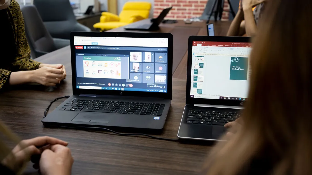 Zespół analizuje dane przy laptopach, co symbolizuje planowanie kampanii Amazon Ads w wielu formatach