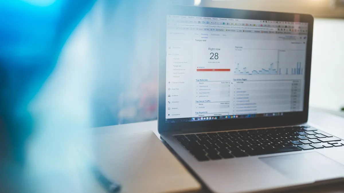 Laptop z danymi analitycznymi symbolizuje kontrolę nad reklamą i oznaczeniami AI