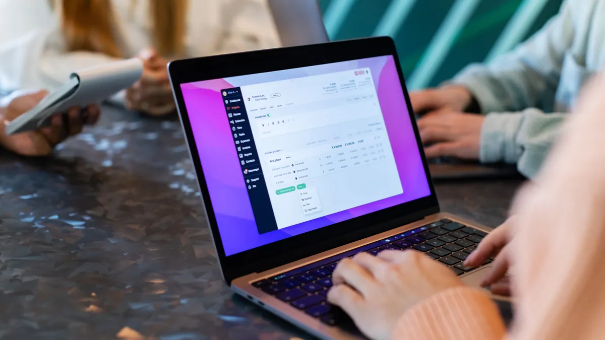 Zespół analizuje dane na laptopie, co symbolizuje krótszą drogę od wyszukania oferty do kontaktu z lokalnym agentem