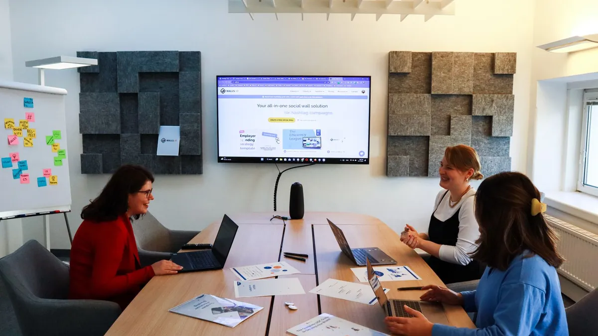 Zespół marketingowy pracuje przy laptopach i omawia zmiany w automatyzacji kampanii