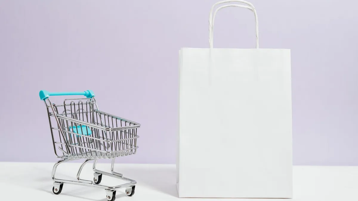 Smartfon z zakupami online symbolizuje kampanie shopping, feed produktowy i analizę ścieżki zakupowej