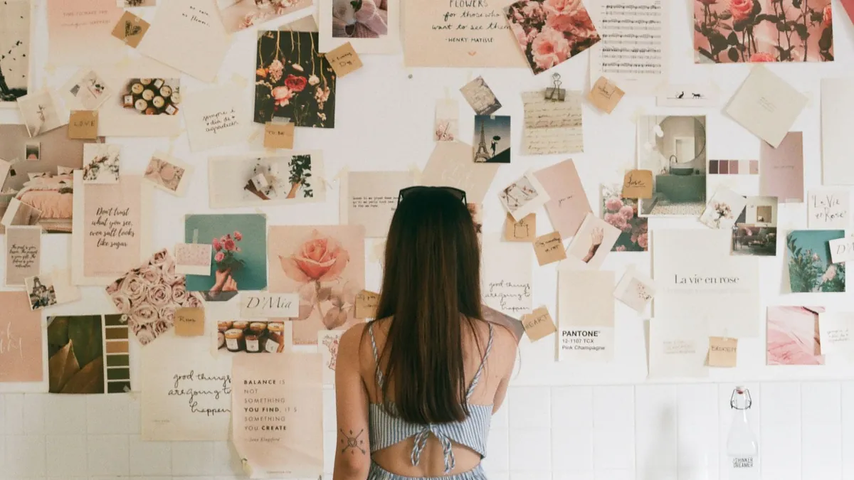 Osoba analizuje tablicę inspiracji, co symbolizuje testowanie wariantów kreacji i zakupowe inspiracje na Pintereście