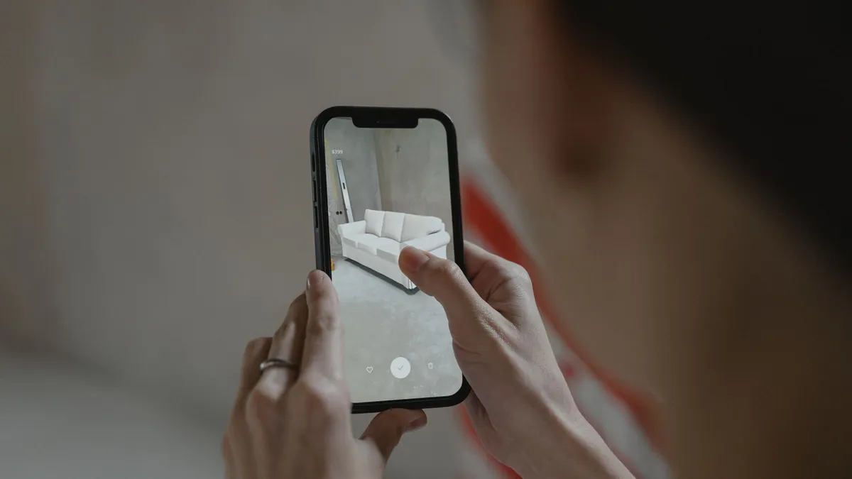 Smartfon pokazuje wizualizację produktu w przestrzeni, co symbolizuje reklamę AR nastawioną na decyzję zakupową
