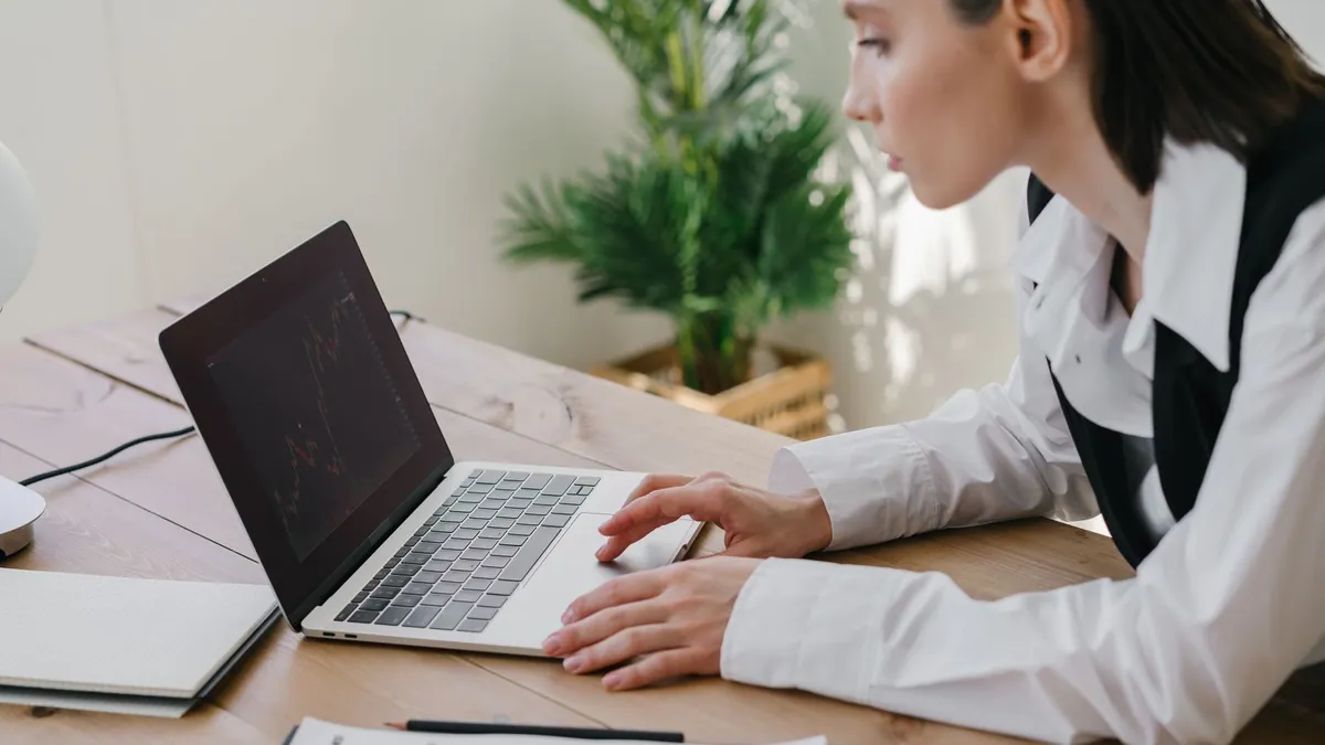Kobieta analizuje wykresy na laptopie, co symbolizuje porządkowanie kampanii Google Display Ads przed migracją do Demand Gen