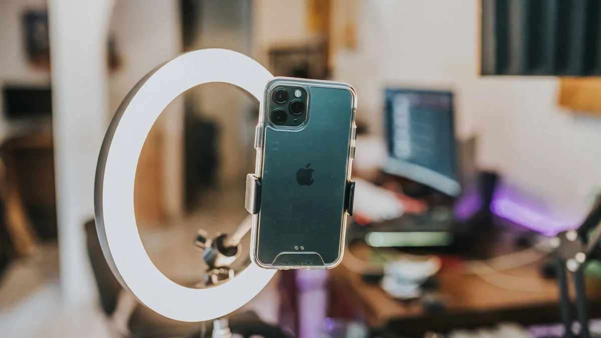 Smartfon w ring light symbolizuje kampanie wideo, których zasięg i częstotliwość można lepiej koordynować w Google Ads