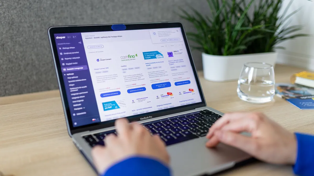 Osoba pracuje przy laptopie z zapleczem sklepu internetowego, co symbolizuje łączenie katalogu produktów, wideo i automatyzacji reklam Meta