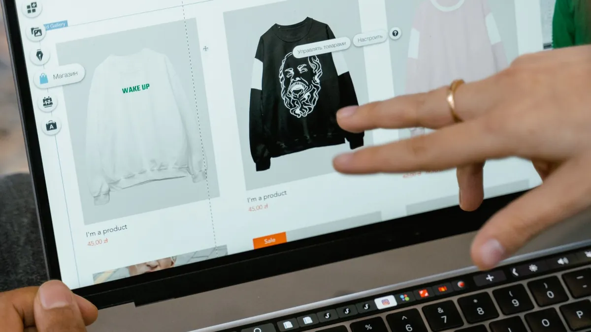 Dłonie robią zakupy online na laptopie, co symbolizuje reklamę produktową i personalizację kreacji