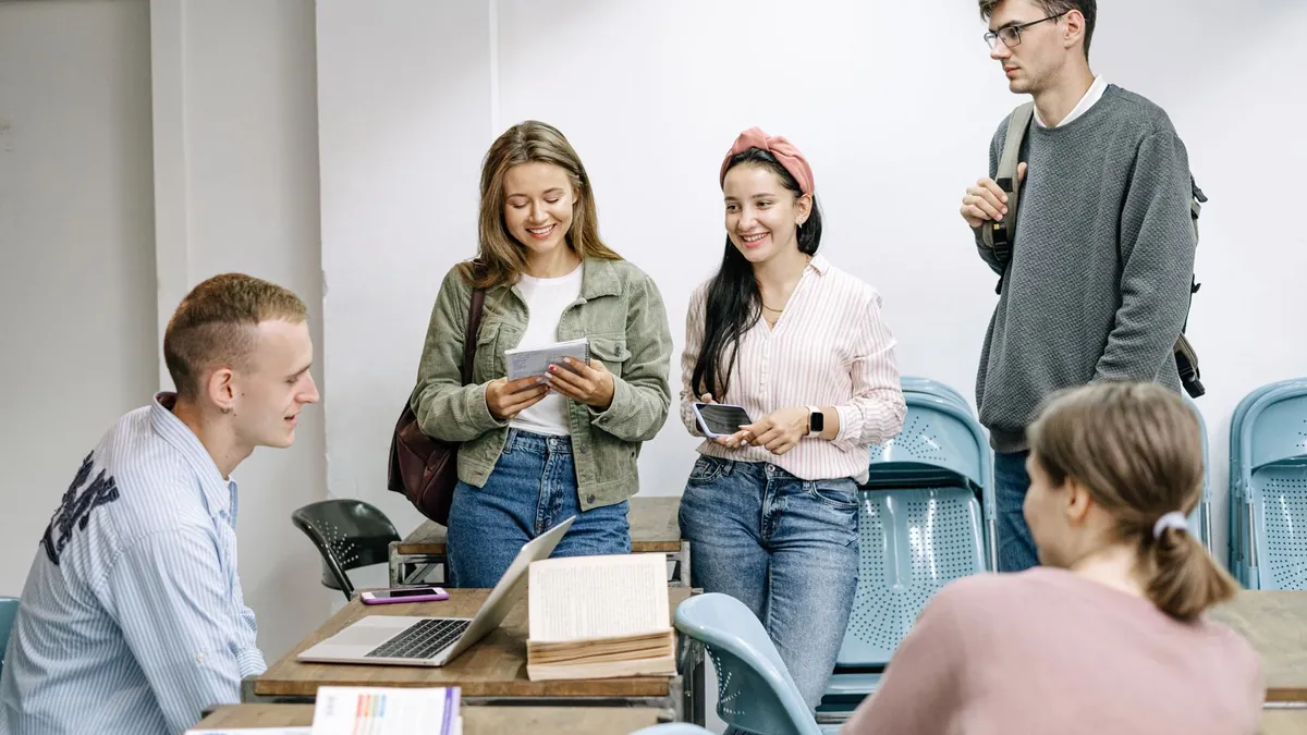 Grupa osób dyskutuje przy laptopie, co symbolizuje wykorzystanie rozmów społeczności do lepszej kreacji i skuteczności reklam na Reddicie