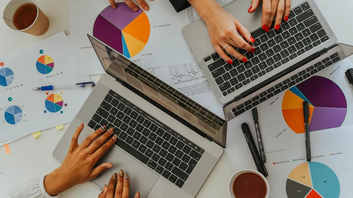 Widok z góry na zespół analizujący wykresy i laptopy symbolizuje porównywanie dwóch wariantów kampanii oraz podejmowanie decyzji na podstawie testu w Reddit Ads