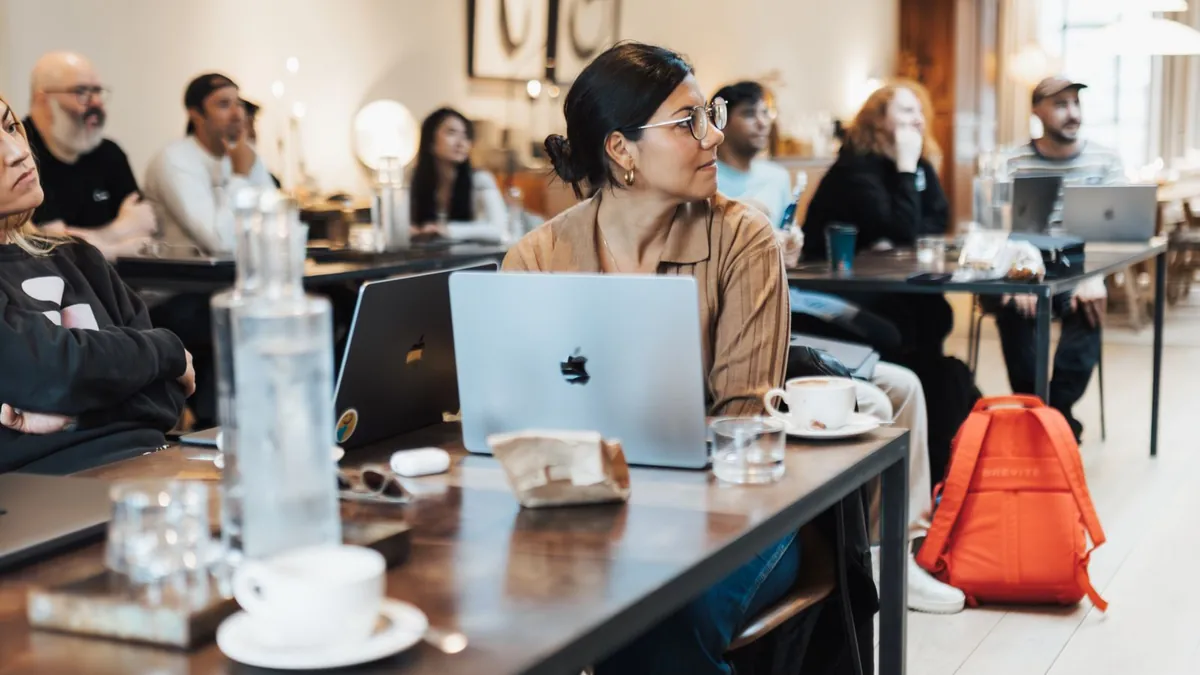 Zespół pracuje przy laptopach podczas spotkania, co symbolizuje połączenie kampanii sprzedażowej z analityką i wspólną oceną danych