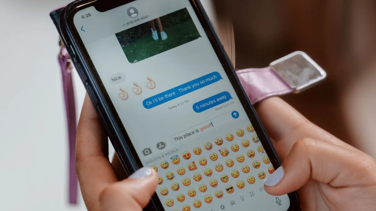 Osoba pisze wiadomość na smartfonie, co symbolizuje przejście z reklamy YouTube do rozmowy z marką