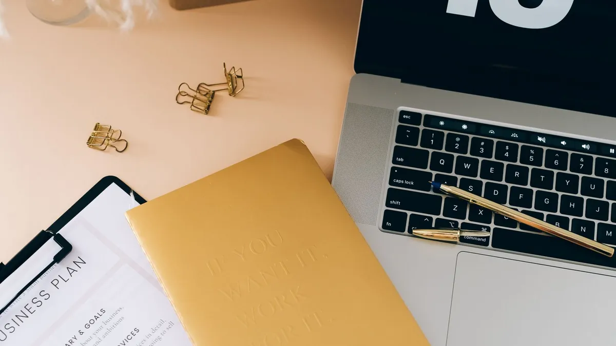 Laptop i plan biznesowy na kreatywnym biurku symbolizują przygotowanie pomysłu do kampanii tworzonej z pomocą Google Flow