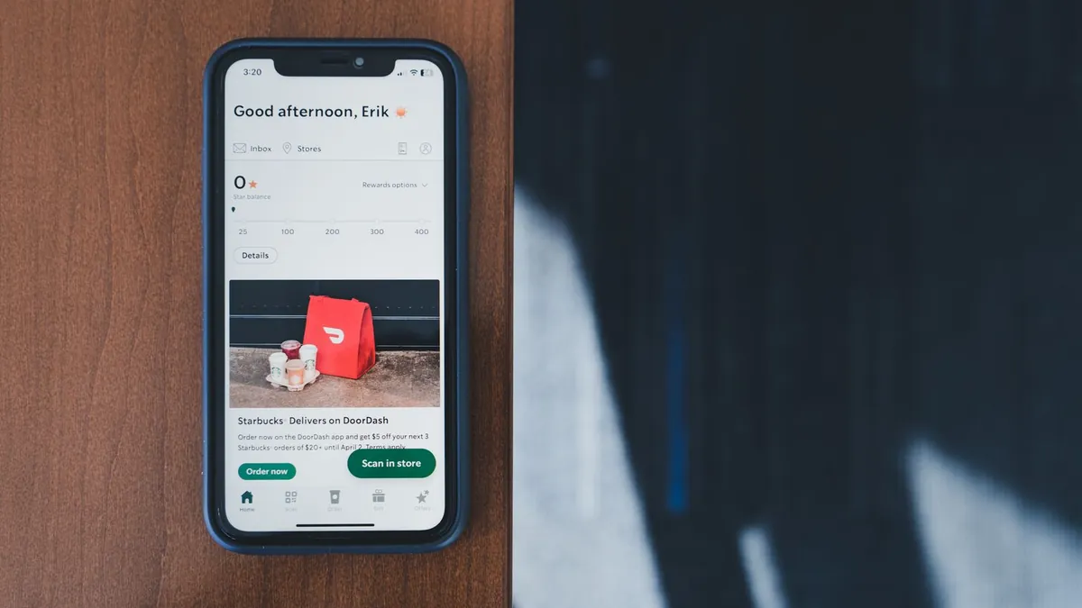 Smartfon z aplikacją zakupową na biurku symbolizuje połączenie organicznych filmów TikTok z płatną optymalizacją Smart+